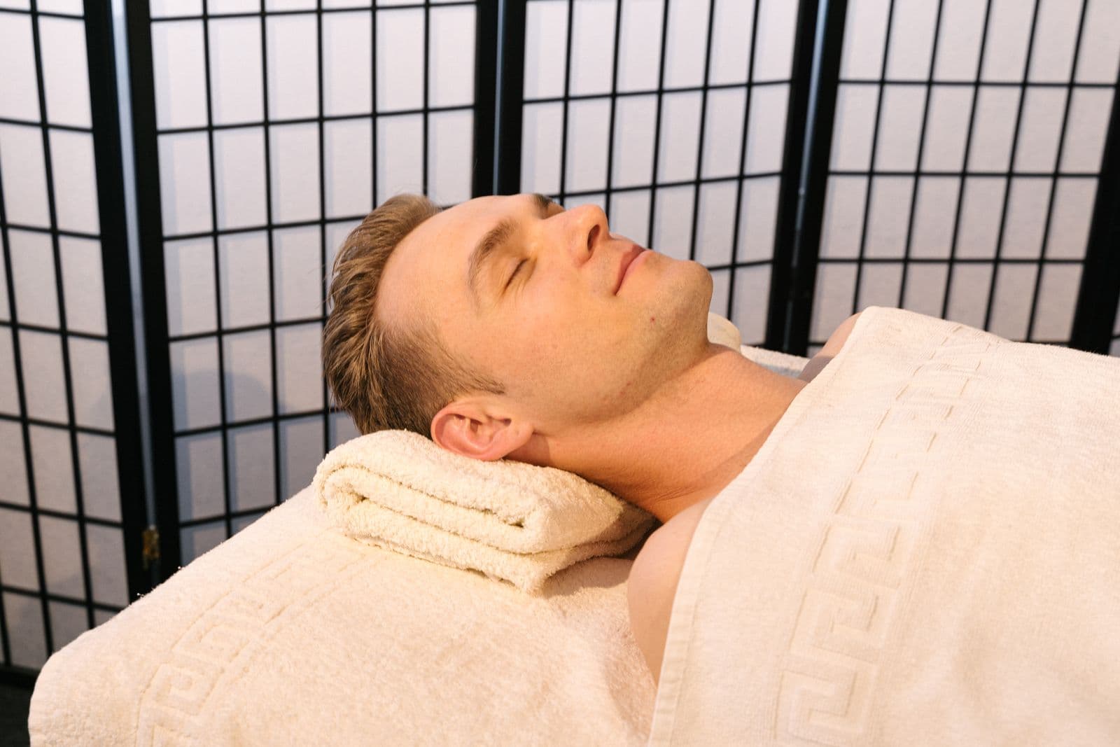 Relaxed male guest resting on a massage table in a private spa setting